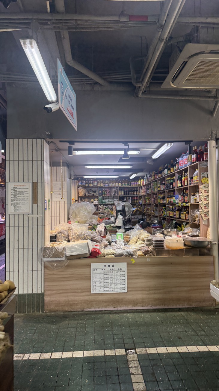 A dry-goods and sauce stall inside Mengxi Market — shelves of soy sauces, pickles, dried goods and pantry staples